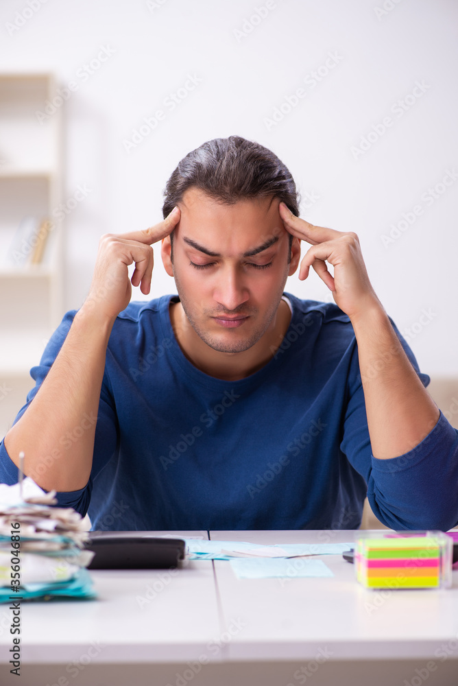Young man in budget planning concept Young man in budget planning concept