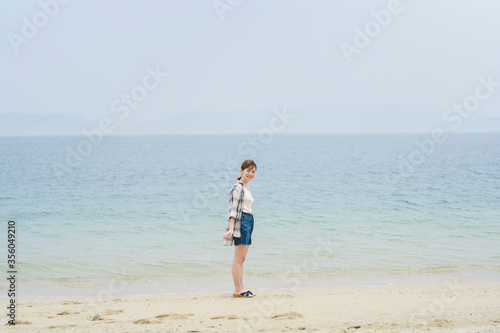 Fototapeta Naklejka Na Ścianę i Meble -  海辺を散策する女性