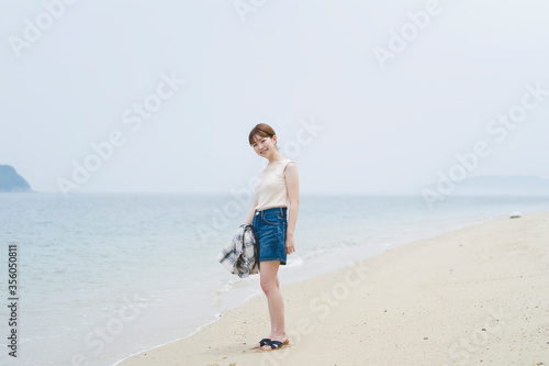 海辺を散策する女性 © peach100
