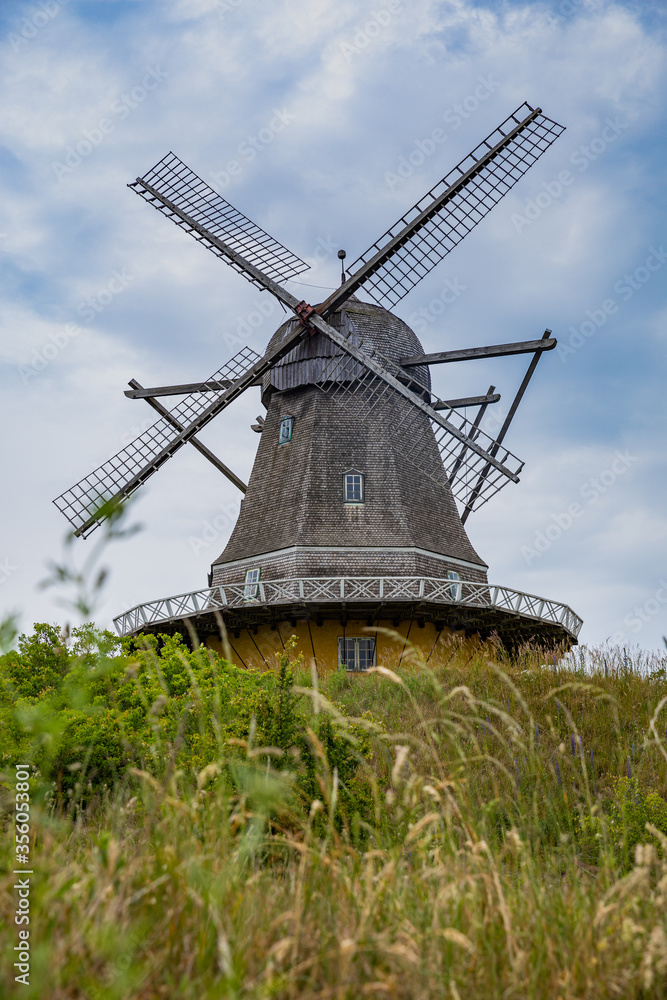 MIll on the hilltop with blue sky and clouds