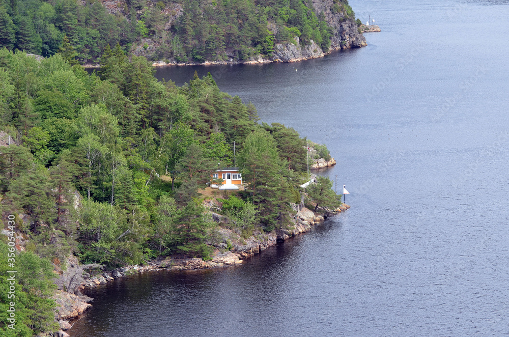 Obraz premium Typical Swedish nature and houses on the shore of the fjord. View from the high bridge over the fjord. The border of Norway and Sweden.Near the town Selater,Sweden