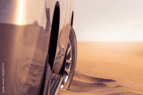 Photography Close up of a golden car stuck in the sand in the Namib desert.