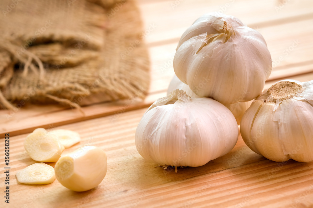 Garlic bulb head and cloves on wooden floor, Herbs and spices are important in cooking Garlic bulb head and cloves on wooden floor, Herbs and spices are important in cooking