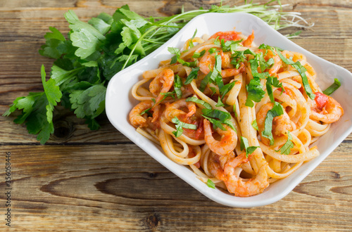 spaghetti with prawns in tomato sauce with herbs.