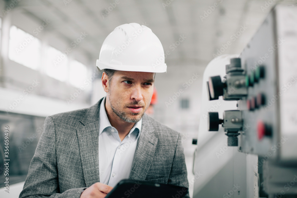 Manager checks machines at the factory. Inspector checks a factory. Manager checks machines at the factory. Inspector checks a factory.