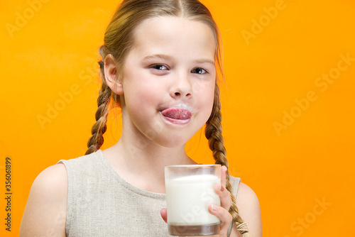Canvastavla girl with pigtails and milk mustache drinks milk on orange background