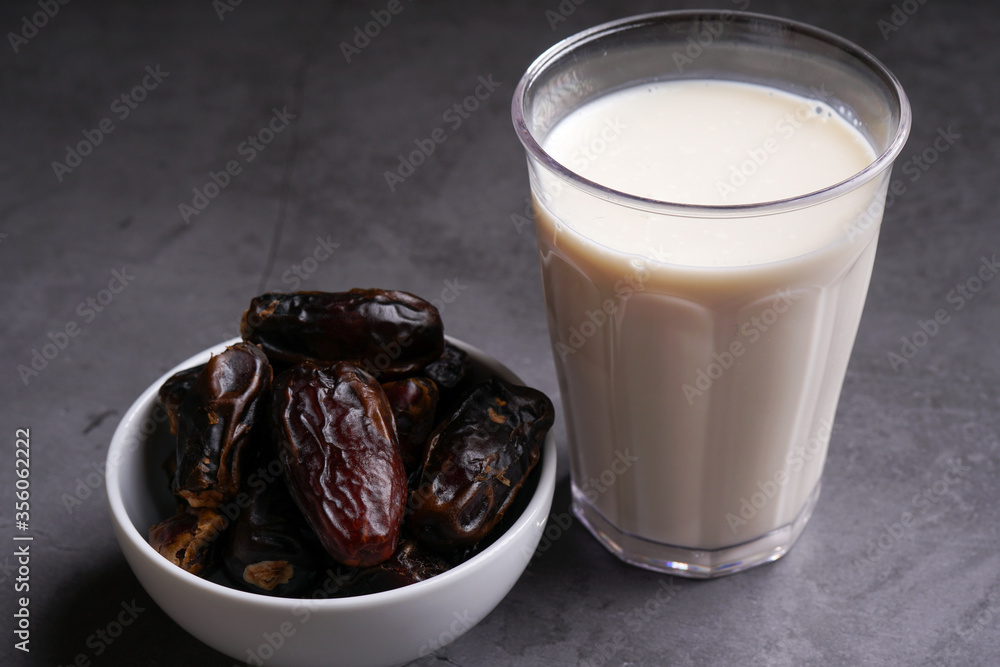 Dates milk and dates in the bowl on grey background.
Dates milk and dates in the bowl on grey background.