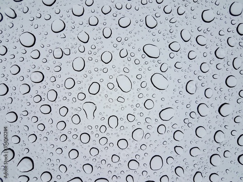 circular water droplets or drops on glass window from rain