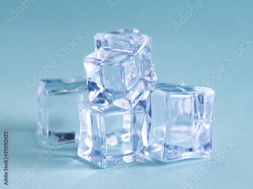 Pile of plastic ice cubes isolated on blue background