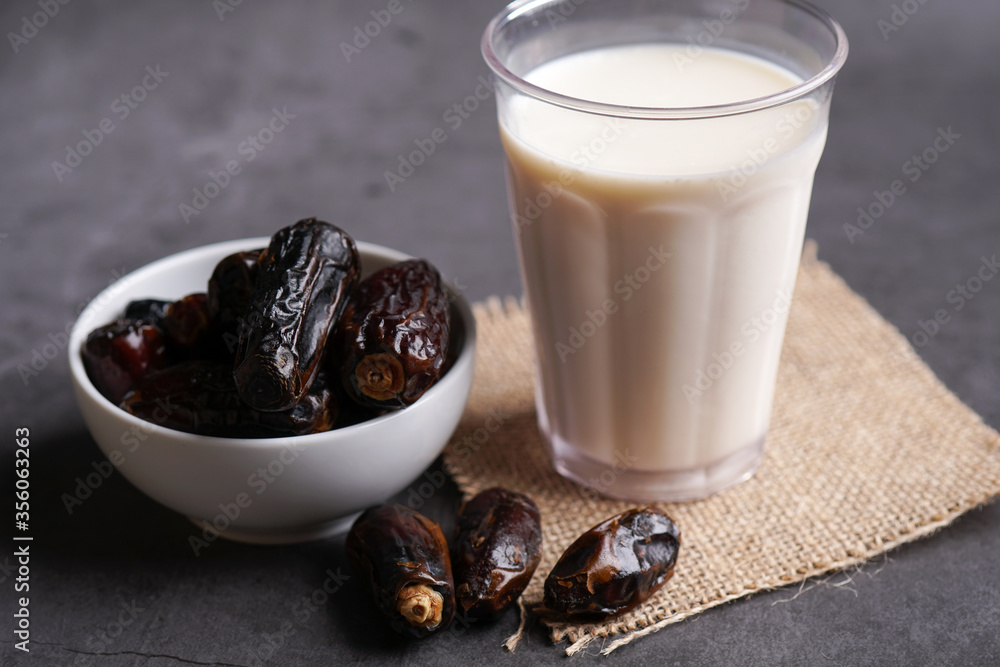 Dates milk and dates in the bowl on grey background.
Dates milk and dates in the bowl on grey background.