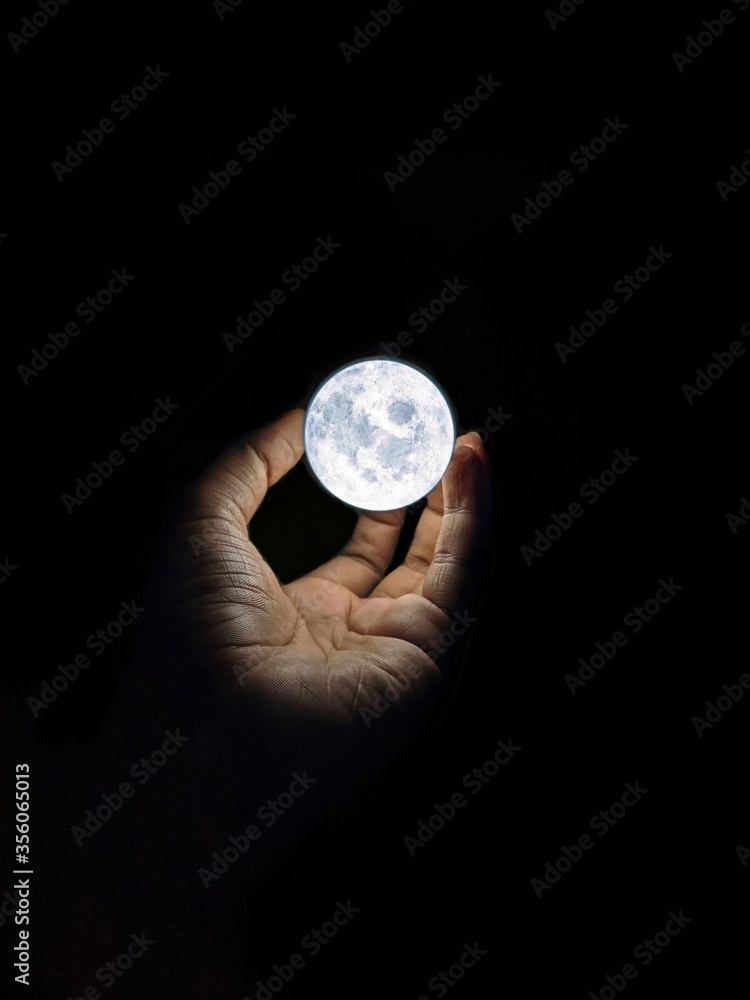 A moon in hand creative photography with black background A moon in hand creative photography with black background