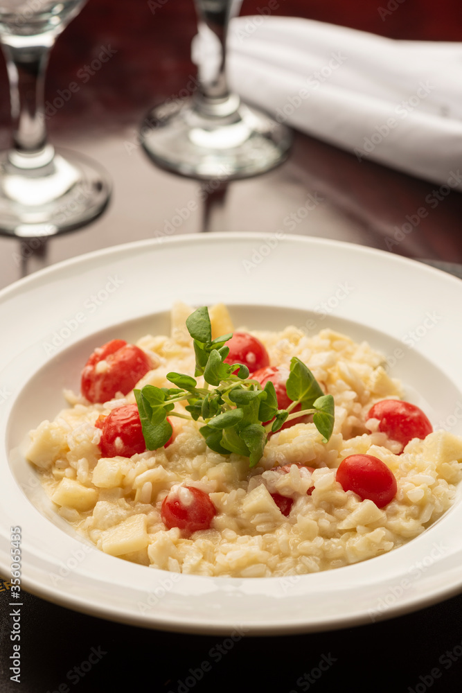 cherry tomatoes cheese risotto and basil on a wooden table cherry tomatoes cheese risotto and basil on a wooden table