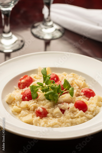 cherry tomatoes cheese risotto and basil on a wooden table
