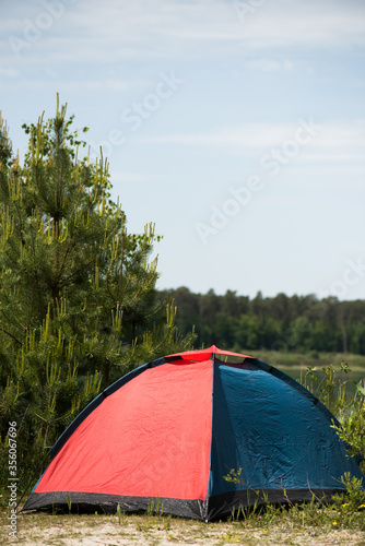 Tent for hiking by the lake in the woods.