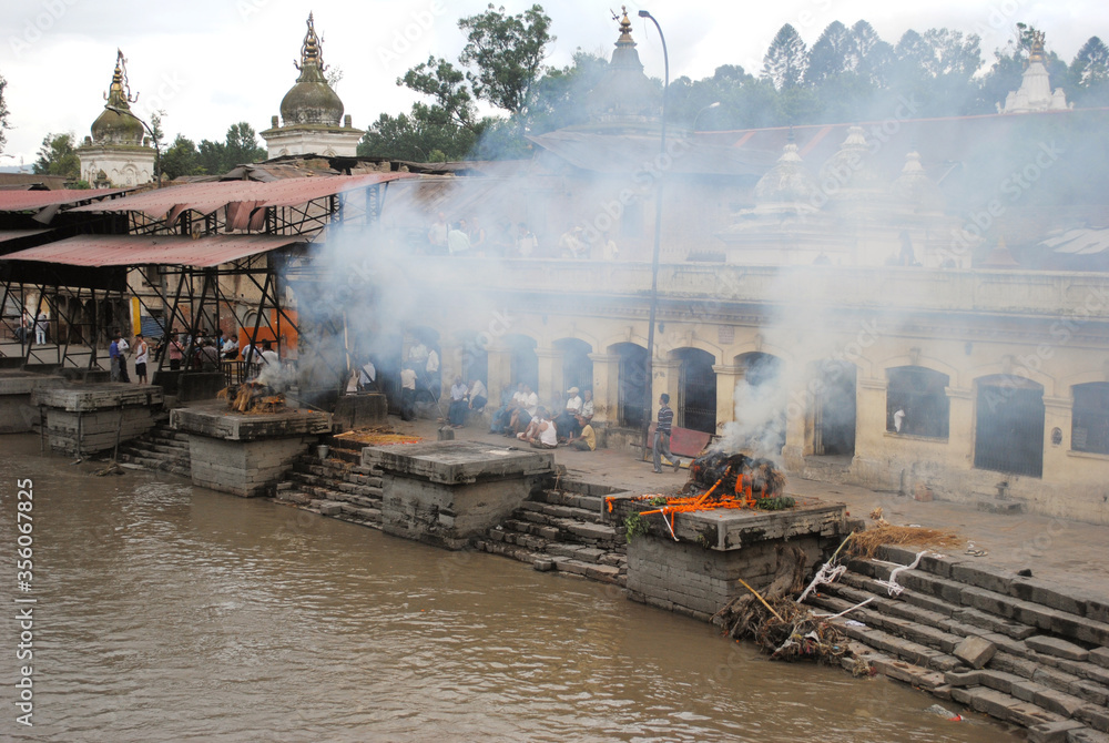Smoke billows from the Arya Ghar during funeral near Pashupatinath Temple amid Bagmati river floats constant at Kathmadu. This is the largest cremation center in Nepal and it is believed that Hindu cr