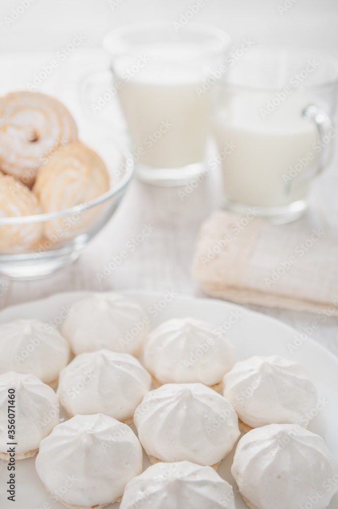 White round marshmallows, two cups of milk, cookies in powdered sugar. White round marshmallows, two cups of milk, cookies in powdered sugar.