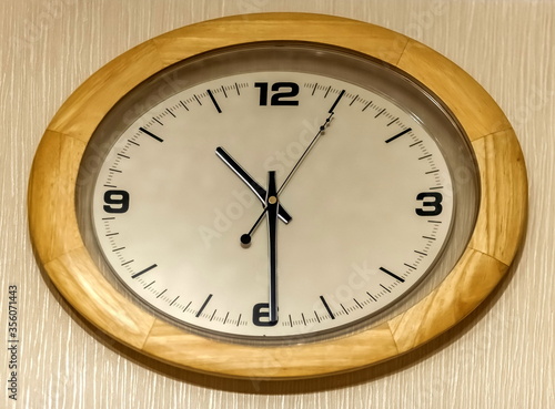 Wall clock in a wooden frame close-up