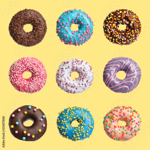 Set with delicious glazed donuts on yellow background