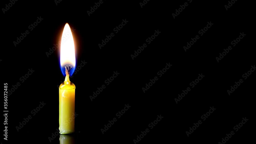 burning wick of a church candle on a black background burning wick of a church candle on a black background