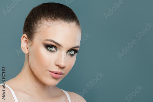 Young cute model woman with clean healthy skin on blue background