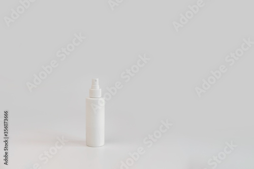 White hand sanitizer cosmetic bottle on gray background with copyspace. New normal concept. Natural, beauty body health cosmetic products.