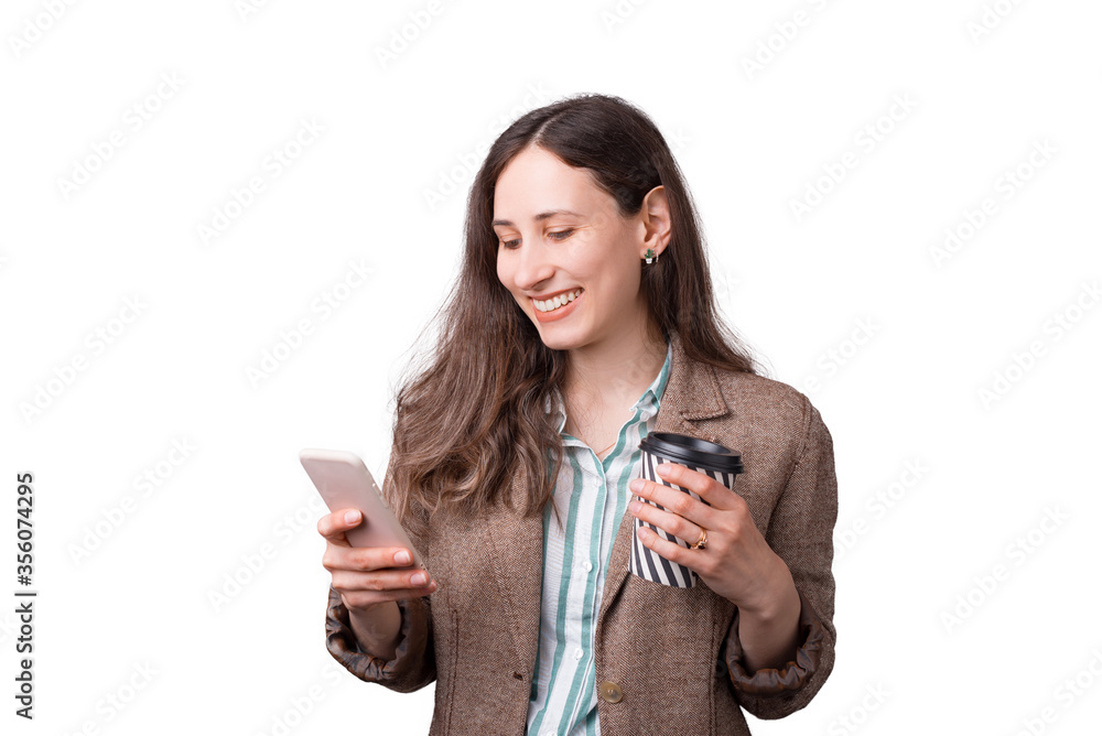 Portrait of cheerful young office woman in suit looking at smartphone and holding cup of coffee to go. Portrait of cheerful young office woman in suit looking at smartphone and holding cup of coffee to go.