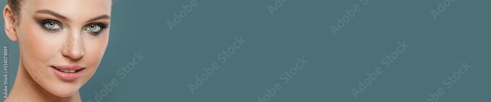 Beautiful woman face close up on blue banner background Beautiful woman face close up on blue banner background