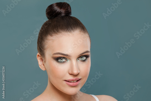 Beautiful young woman with clean healthy skin on blue background