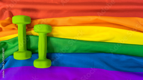 Dumbbells sports on the rainbow flag LGBT flag for design. The concept of sports and a healthy lifestyle in the LGBT community.