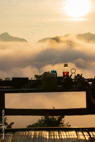 Silhouette of Thai ingredients and condiment on wooden terrace of noodle shop during a beautiful morning sky with waves of fog at Baan Ja Bo village viewpoint of Pang Mapha Mae Hong Son Thailand.