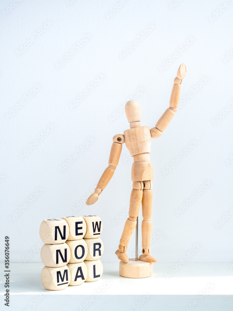 New Normal, words on wooden alphabet cube and wooden figure. New Normal, words on wooden alphabet cube and wooden figure.