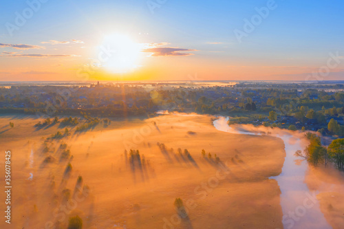 Foggy sunrise over the countryside, fog in the lowlands over the flooded swamps along the river. Landshat aerial view
