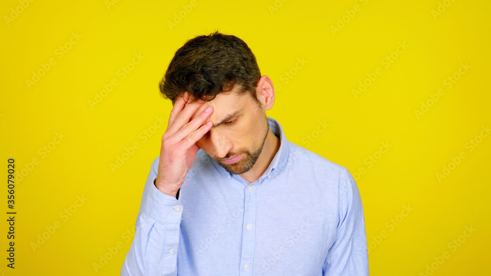 Handsome bearded man with a headache on a yellow background with copyspace. Pensive guy rested his fingers on his head Handsome bearded man with a headache on a yellow background with copyspace. Pensive guy rested his fingers on his head