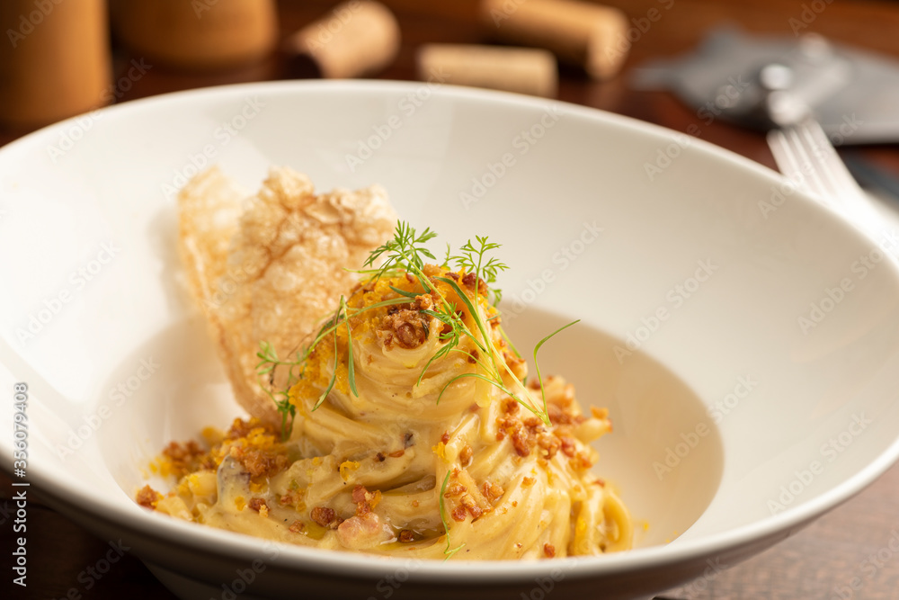 Carbonara pasta on white plate with a blurred background Carbonara pasta on white plate with a blurred background
