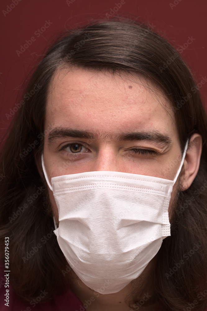 Caucasian young man in his late teens wearing a white facemask Caucasian young man in his late teens wearing a white facemask