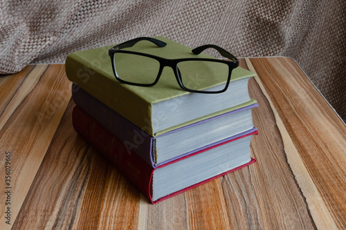 books stacked and glasses are lying on the table