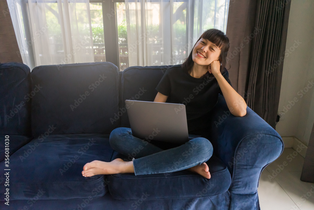 Young woman relex time working with laptop on sofa at home. Work from home concept.