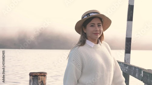 Beautiful asian woman walking on wooden dock with relax at Akaroa Harbour, New Zealand.