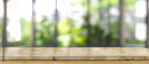 Empty wooden counter bar, wooden table with blurred backyard background