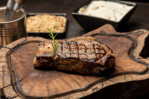 steak on a wooden board with a blurred background with side dishes