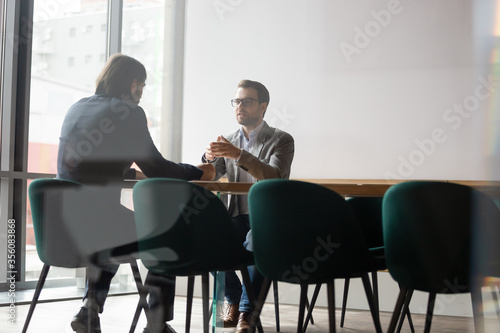 Negotiations process behind wall door concept, human resources manager interviewing candidate of company position, two businessmen business meeting, insurance broker makes offer deal with firm client