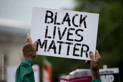 A person holding a black lives matter banner at a protest photo