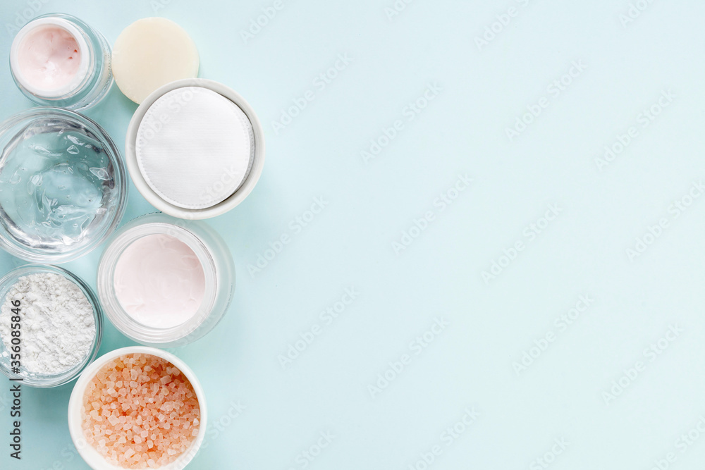 Skin care products: sea salt, face cream, alginate mask, gel and soap on light blue background, top view. Skin care products: sea salt, face cream, alginate mask, gel and soap on light blue background, top view.