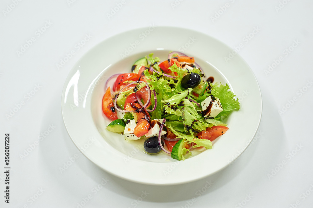 A bowl of salad on a white plate A bowl of salad on a white plate