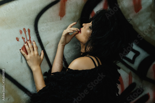 Freaky woman in dark tunnel with graffiti photo