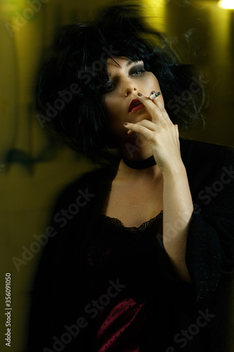 Freaky woman with black hair smoking a cigarette