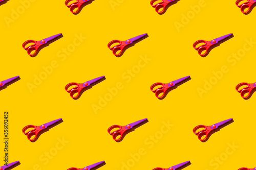 Seamless pattern of figure scissors on orange background. Top view. Hard light.