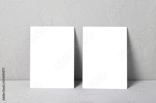 Mock up of two postcard on a gray background next to sprig of eucalyptus.