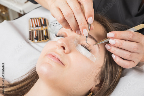 mujeres trabajando en centro de belleza, estética y bienestar con las mascarillas y EPIS reglamentarios por el virus COVID-19 photo