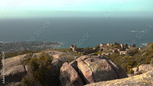 A static shot in Corsica of the abandoned village of Occi. The strong breeze moves the bushes, the sea stretches out into the horizon. 
 photo